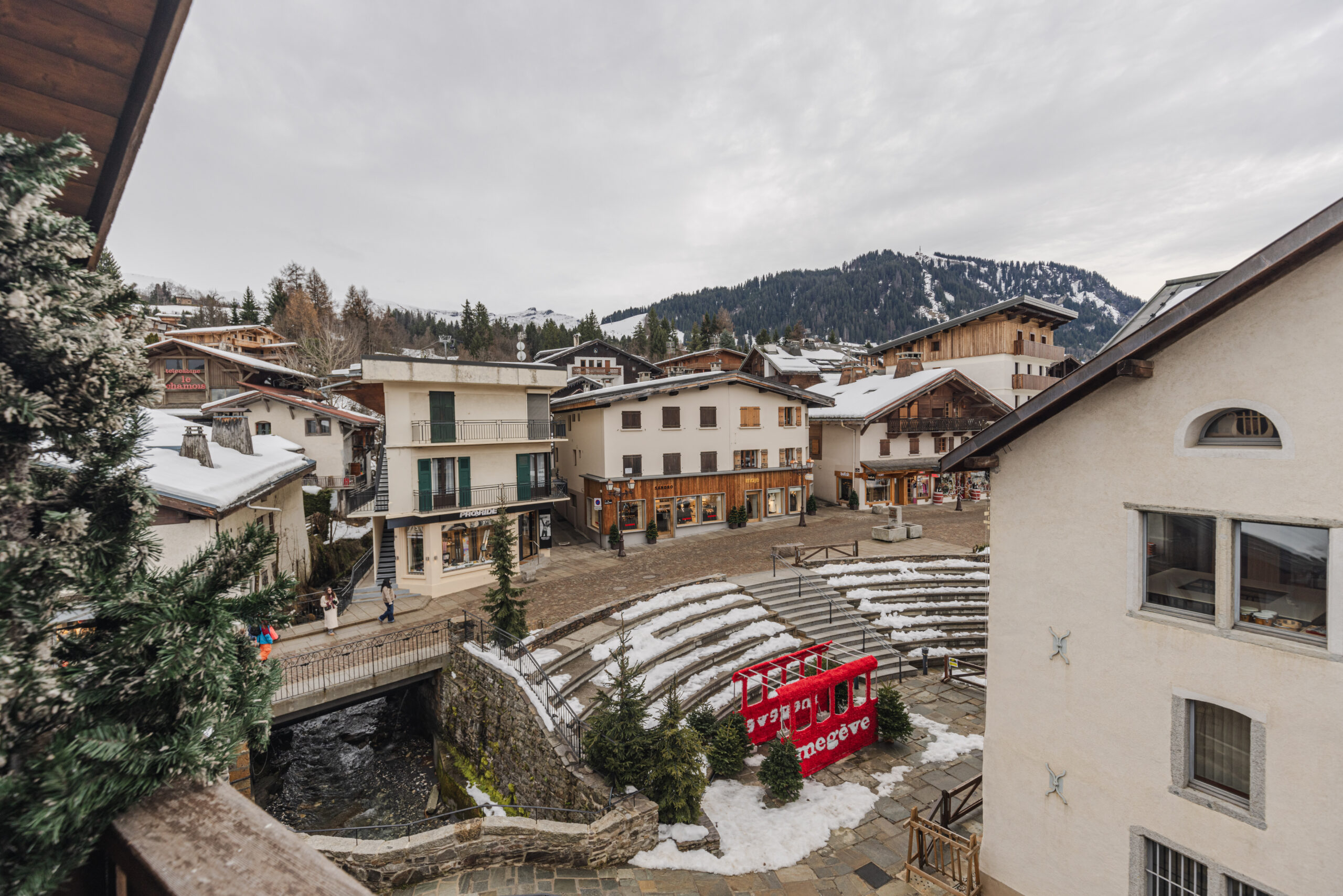 Vue sur le village, l'office du tourisme et les montagnes depuis le balcon de l'appartement Megève sous les toits.